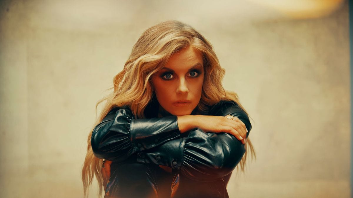 Lindsay Ell with long blonde hair wearing a black leather jacket.