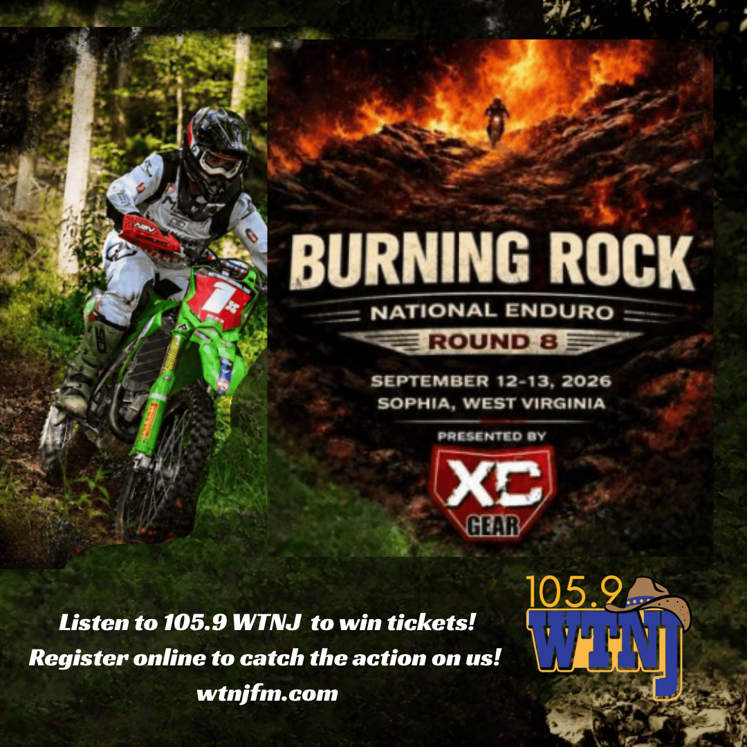 Mountain biker riding through a forest trail with a Burning Rock event poster nearby.